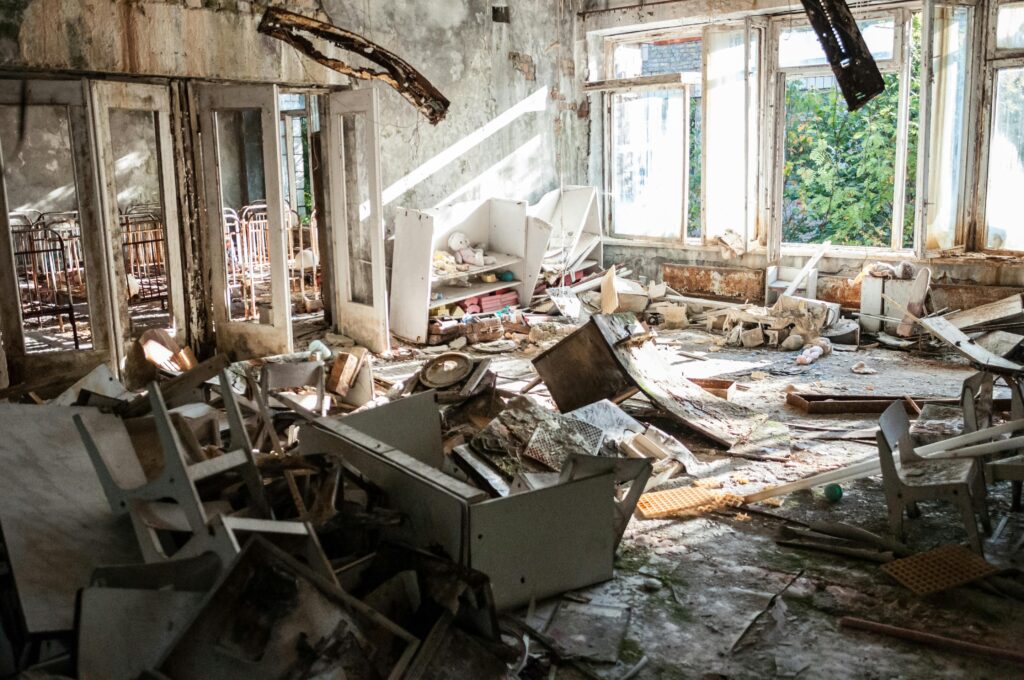 pexels-photo-1411392-1411392 A desolate room filled with decayed furniture, debris, and broken windows, illustrating urban decay.