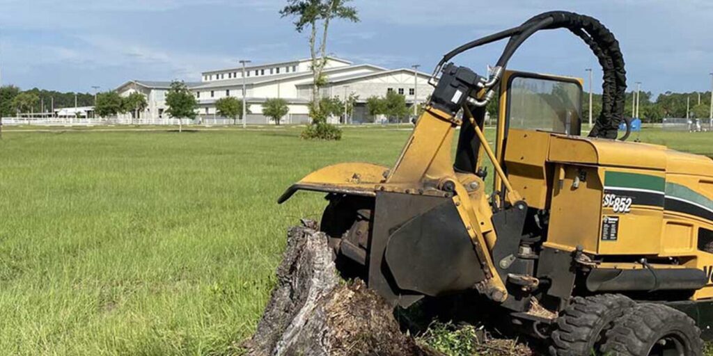 Photo by Robert's Stump Grinding a tractor that is sitting in the grass